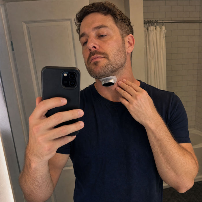 A man at the bathroom mirror adjusting the VoroHal Sleep Aid under his chin