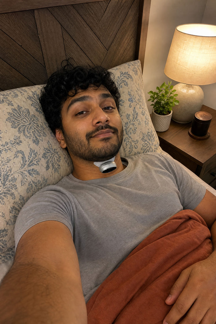 A man lying back on his pillow wearing the VoroHal Sleep Aid under his chin